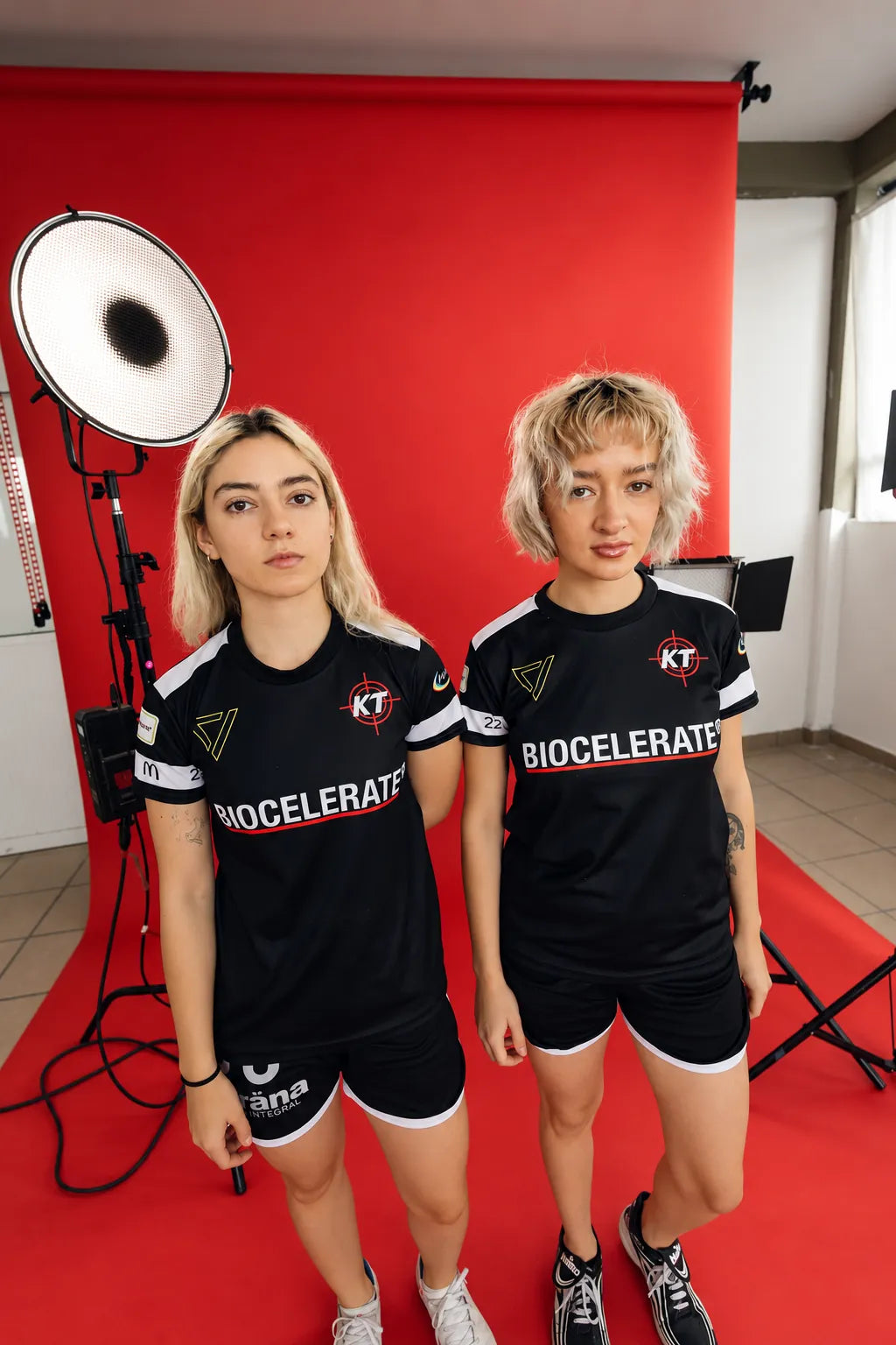 Dos atletas con jersey Biocelerate en un estudio rojo